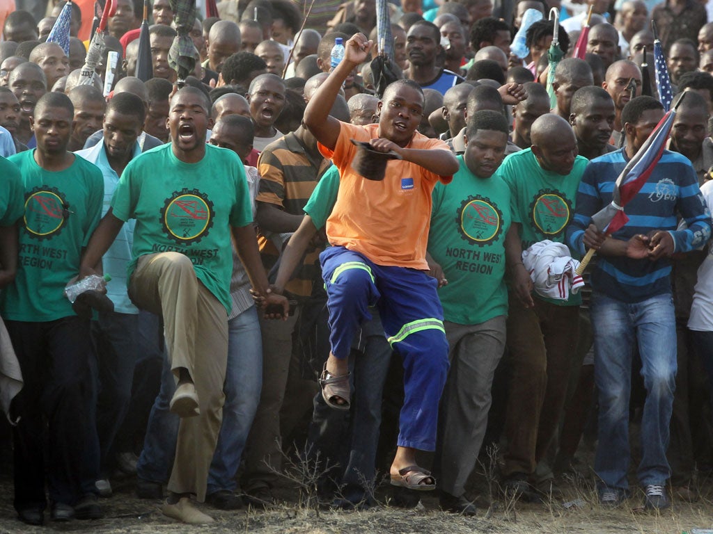 Mine workers sing and dance during a memorial service at the Lonmin Platinum Mine