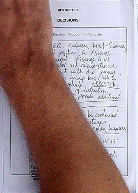 Half of a document carried by a police officer, which outlines that Julian Assange is to be arrested in any circumstances if he comes out of the Embassy of Ecuador, in central London