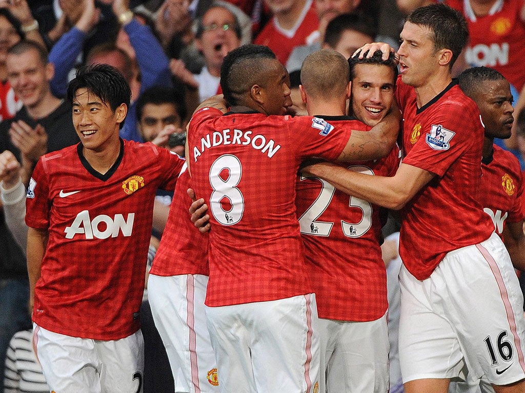 Van's the man: Robin van Persie is mobbed by his team-mates after his first goal for United yesterday