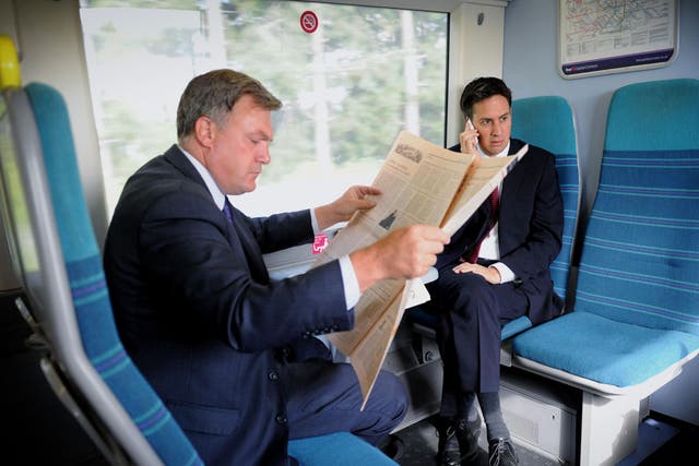 Quiet area: Ed Balls and Ed Miliband travel together - but separately