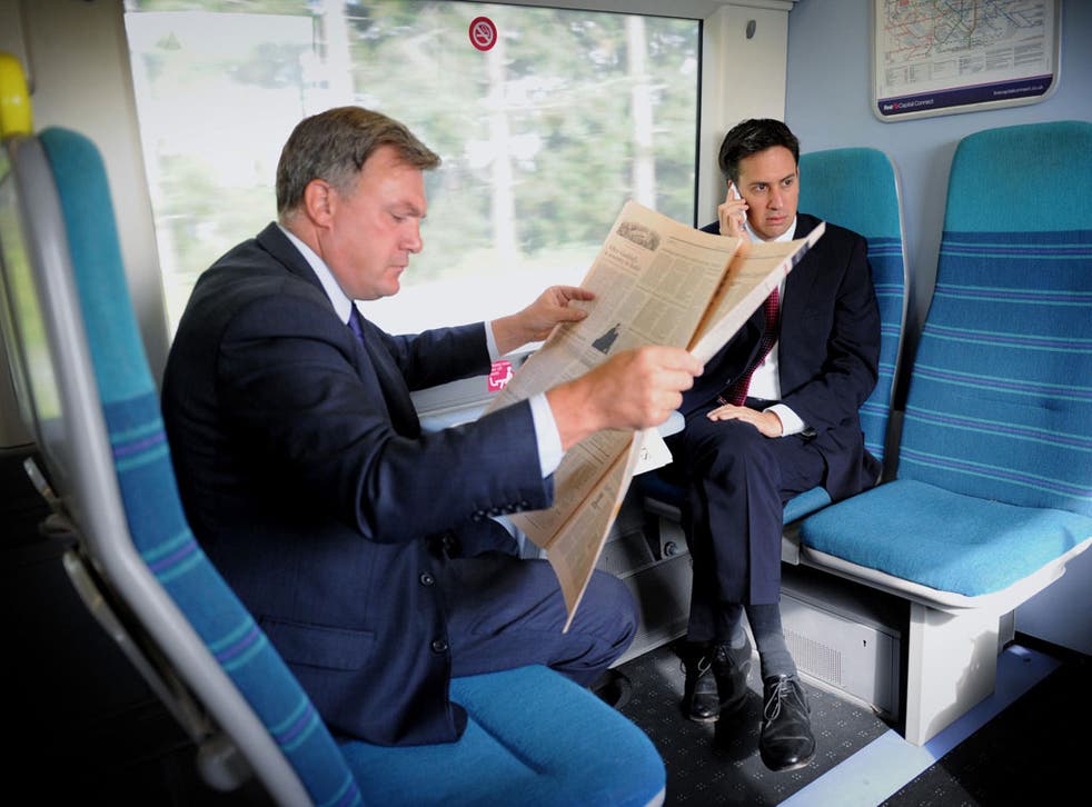 Quiet area: Ed Balls and Ed Miliband travel together - but separately