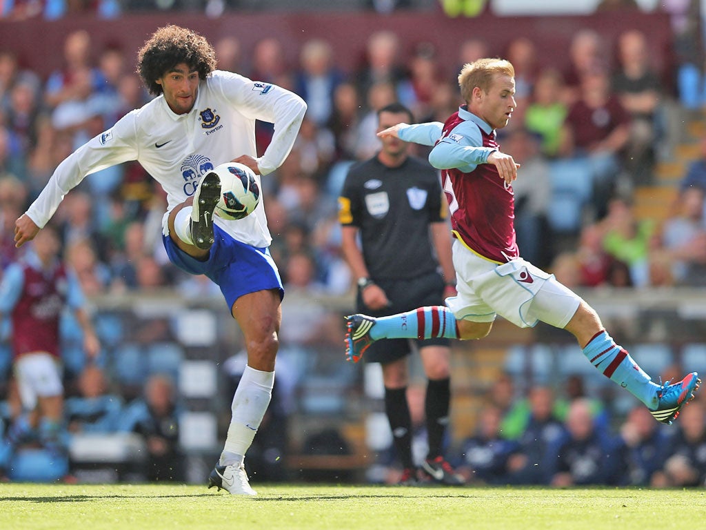 No pressure: Marouane Fellaini takes the ball comfortably despite a flying challenge from Villa's Barry Bannan