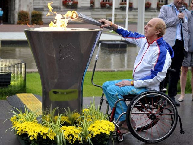 Torchbearer Simon Richardson lights the Paralympics Cauldron outside City Hall in Cardiff