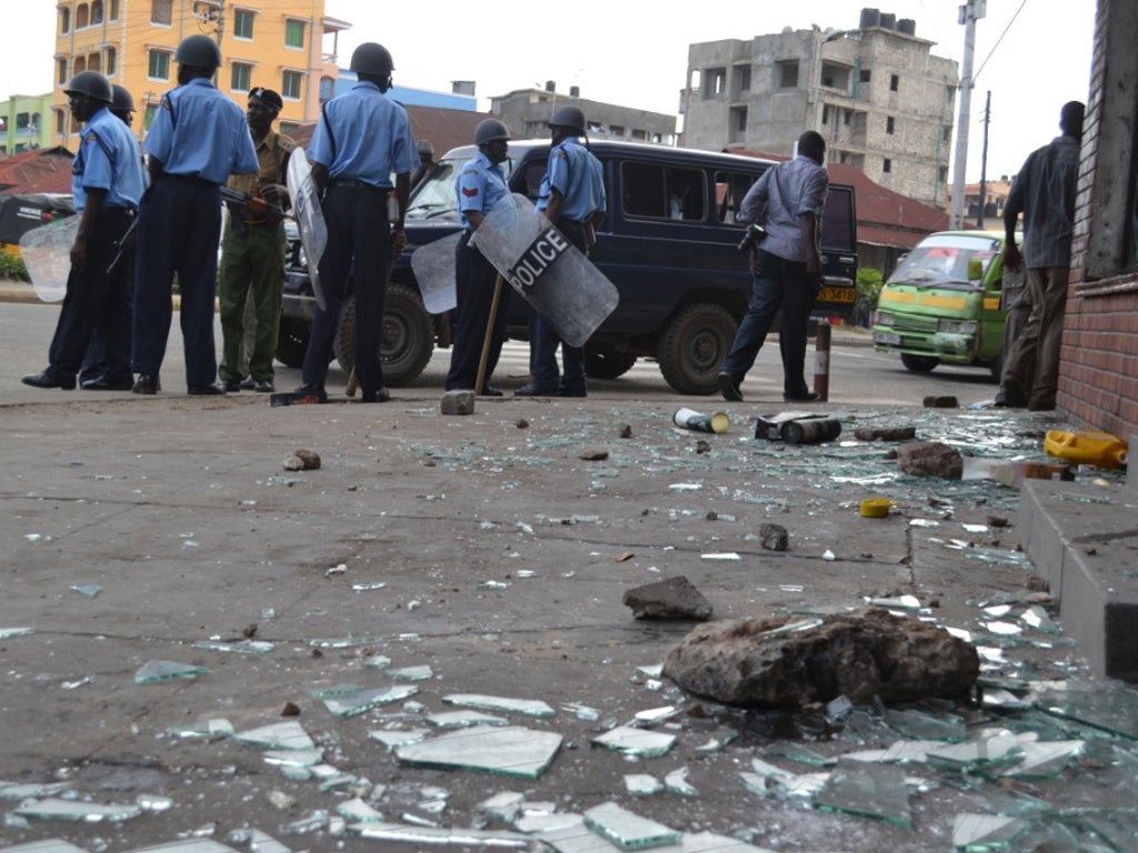 Police survey the damage following rioting in the coastal city of Mombasa