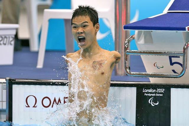 Tao Zheng of China celebrates winning the men’s 100m backstroke
