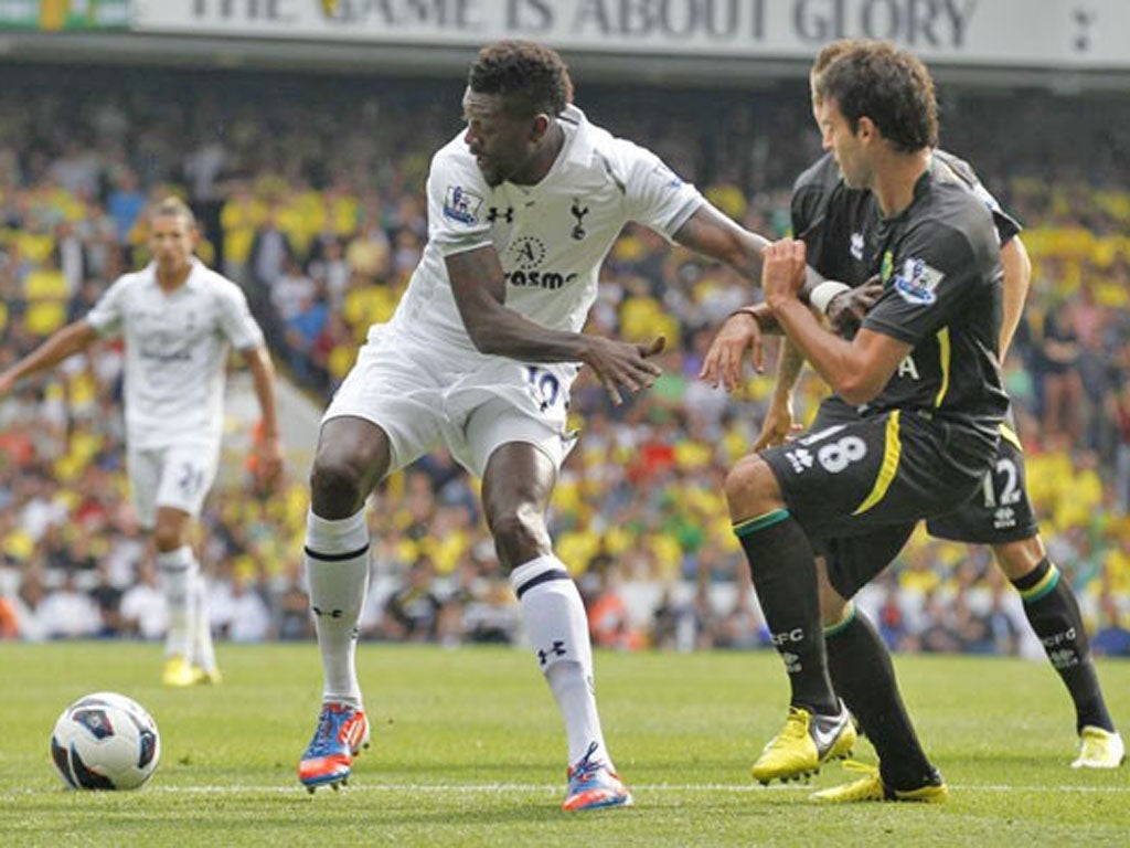 Tottenham Hotspur's Emmanuel Adebayor, left, competes with Norwich City's Javier Garrido at White Hart Lane, London