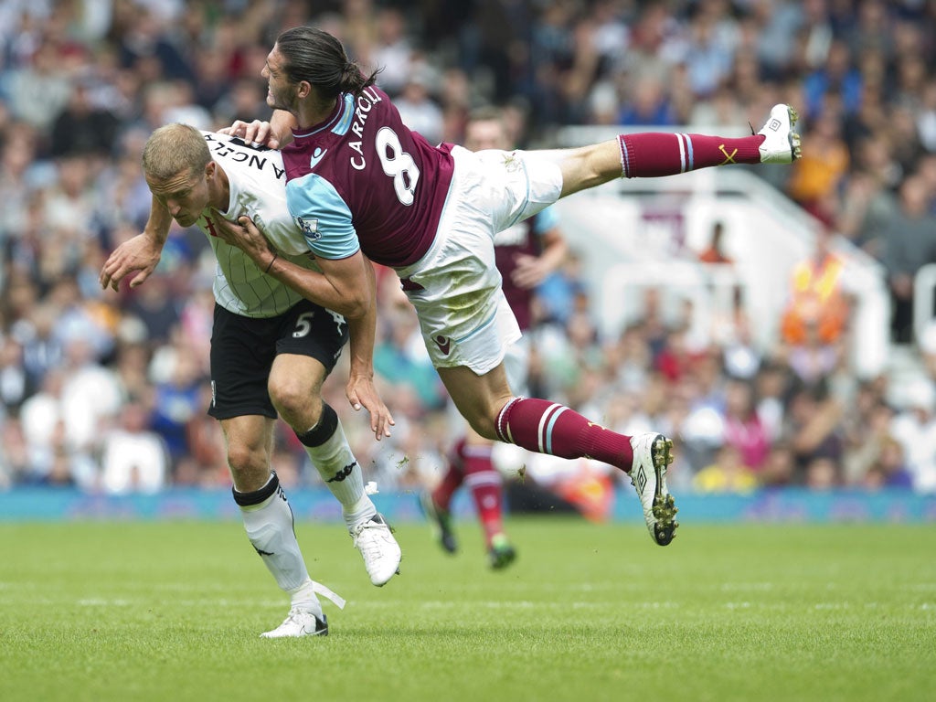 Andy Carroll collides with Fulham's Brede Hangeland