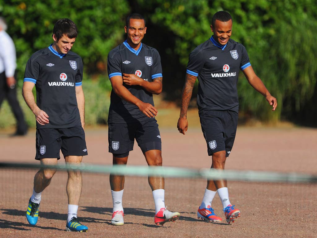 Leighton Baines jokes with Theo Walcott during an England training session