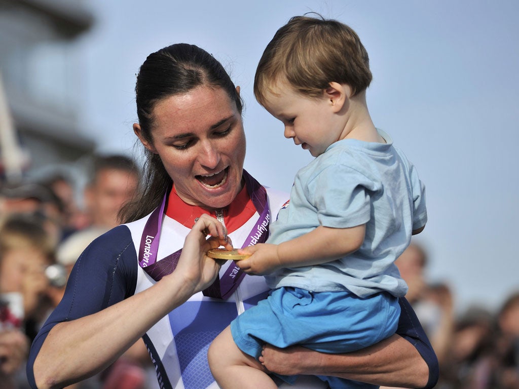 Sarah Storey shows her latest gold to her nephew Gethin yesterday