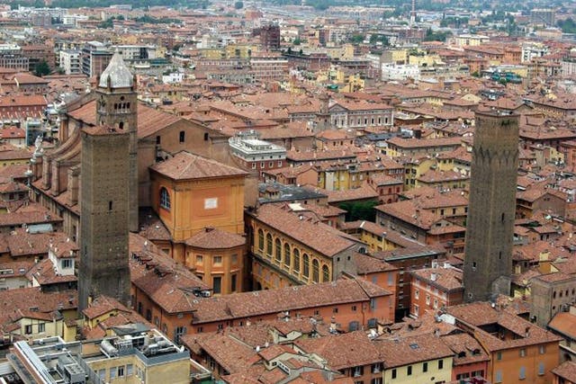 On the tiles: the red roofs and towers of Bologna