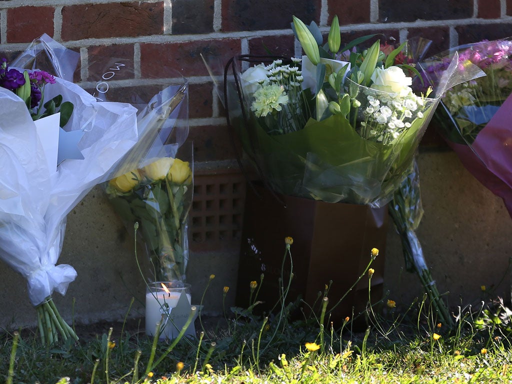 A candle and floral tributes from well wishers are placed at the house of the al-Hilli family in Claygate