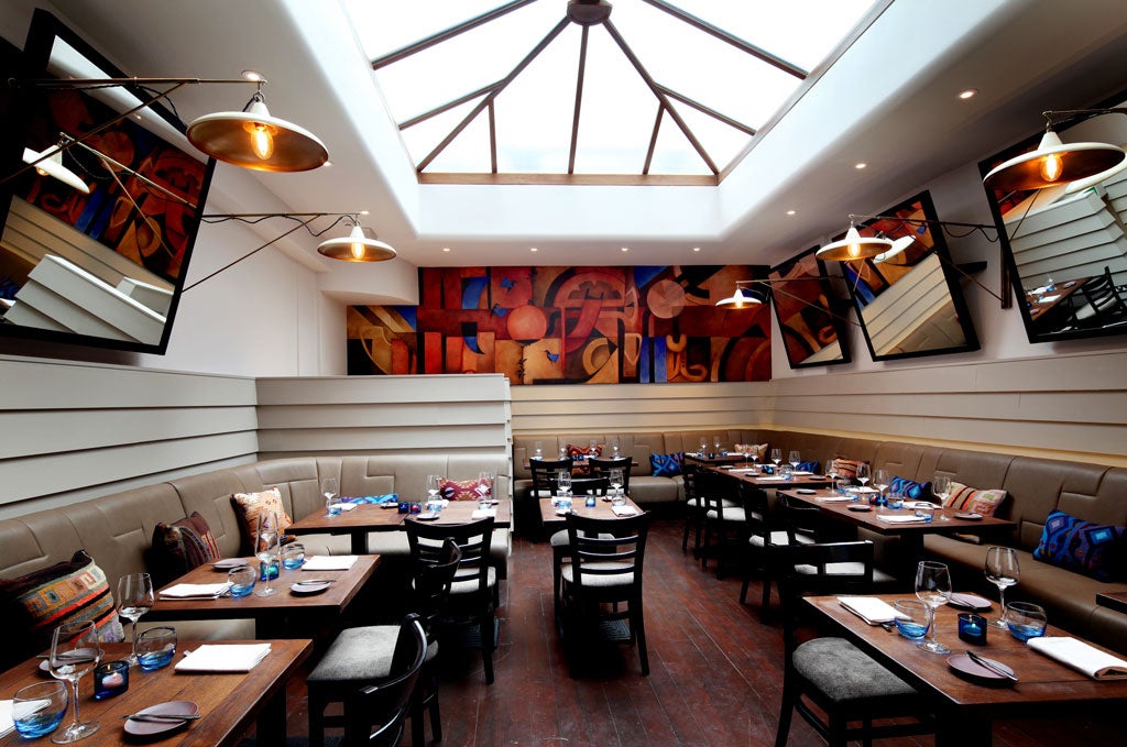 Lima's main dining room, designed by Eric Monroe, is all muted beige enlivened with a busy mural