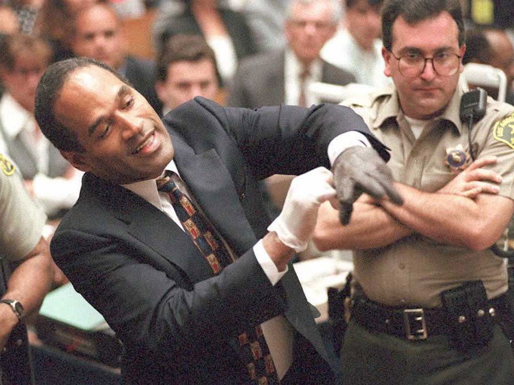 Evidence: O J Simpson, above, trying the infamous glove at his trial