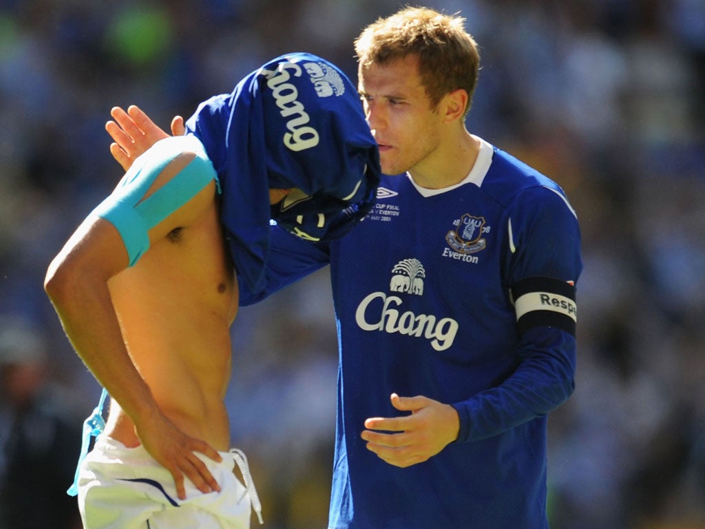 No hiding place: Phil Neville (right) consoles team-mate Tim Cahill after Everton came so close to a trophy in their 2009 FA Cup final defeat