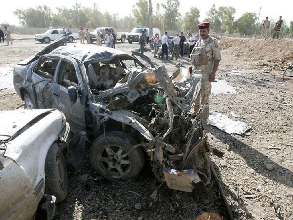 Iraqi soldier inspects the site of a blast in a car park at the rear gate of the the state-owned North Oil Company