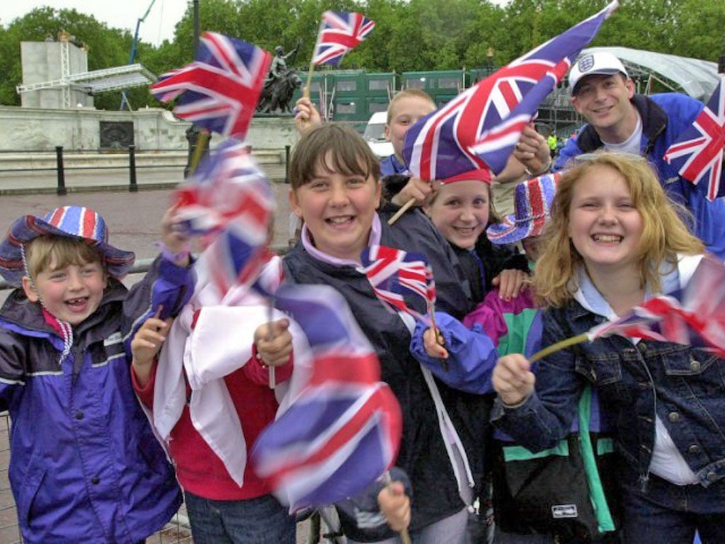 Children wave their Union Jack flags outside Buckingham Palace