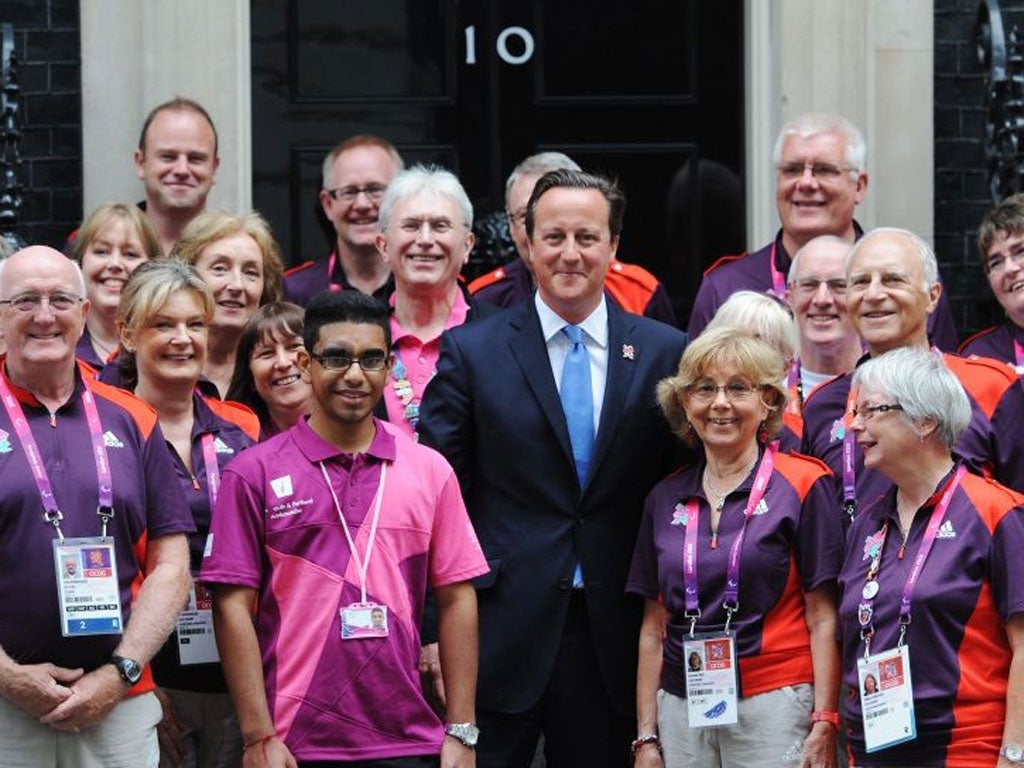 Prime Minister David Cameron poses with some gamesmakers after inviting them to Downing Street in London before they take part in the athletes parade