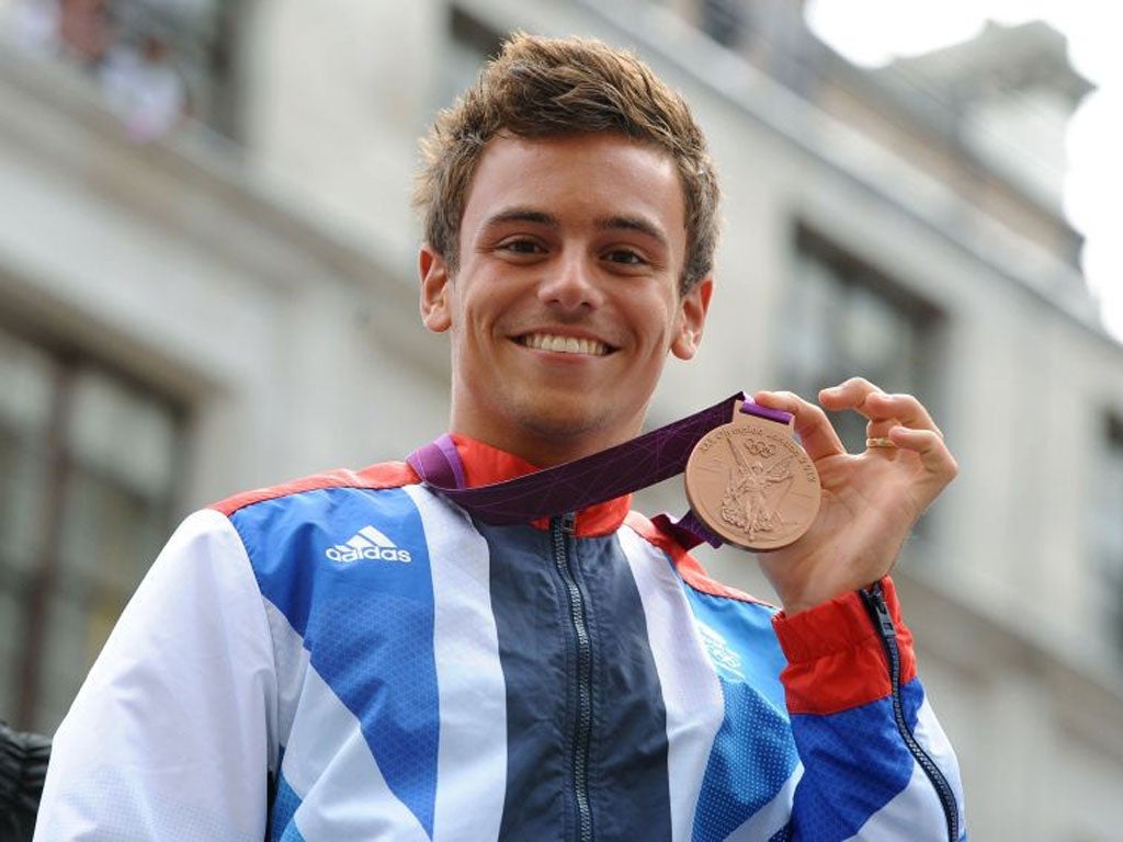 Diver Tom Daley holds his Bronze medal during the parade