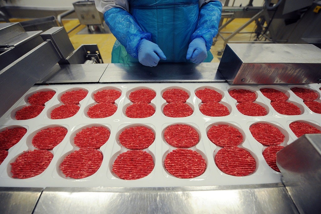 A technician works on a burger production line