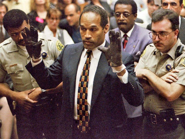<p>OJ Simpson wears the blood-stained gloves during his murder trial in Los Angeles in 1995</p>