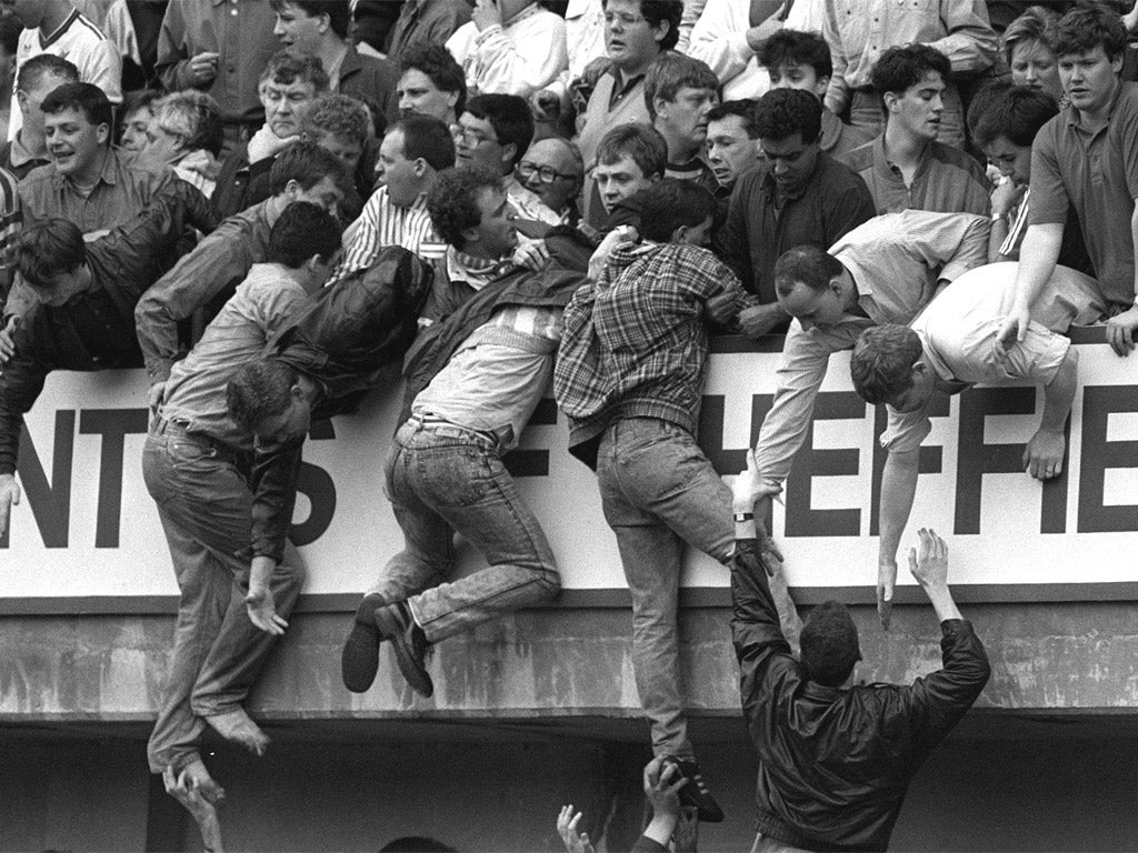 Supporters are pulled to safety in the upper tier of the Leppings Lane stand