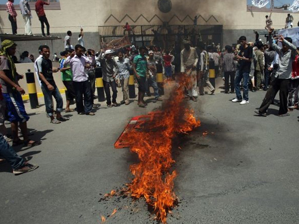 Yemeni protesters gather around fire during a demonstration outside the US embassy