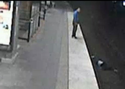 A man is seen on CCTV footage about to rob a person who has fallen onto train tracks