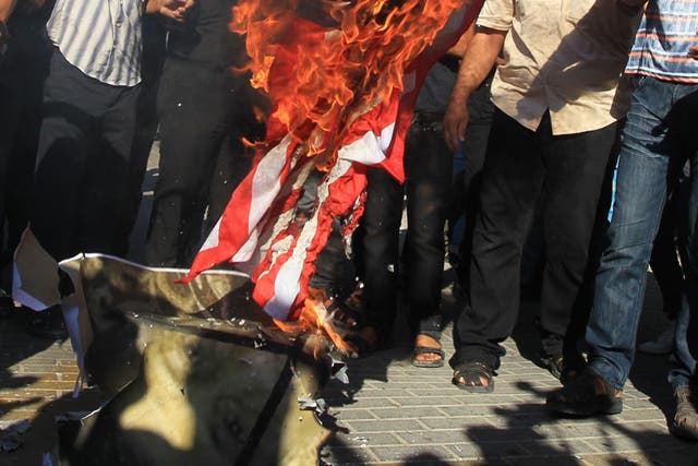 Islam's Fury: Palestinian men burn the US flag in front of the United Nations HQ in Gaza City last week