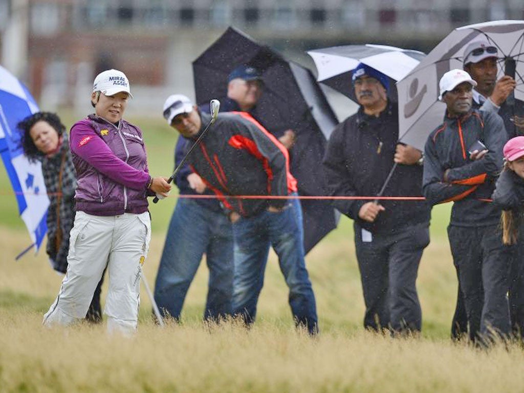 Jiyai Shin plays her third shot to the first hole in appalling conditions at the Women’s British Open