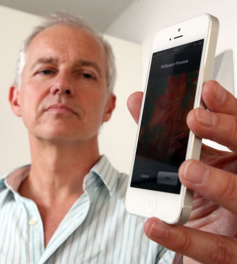The Independent journalist David Phelan is pictured assessing the merits of the new Apple IPhone 5 4g phone in London