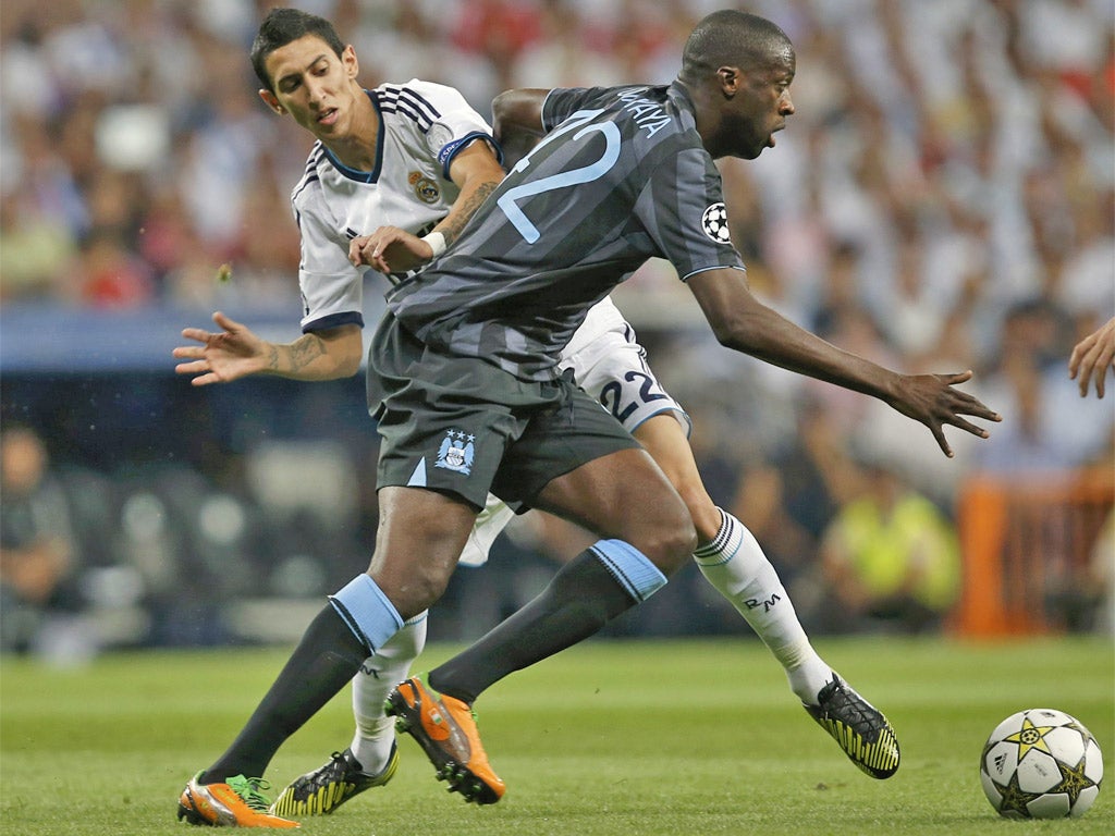 Manchester City's Yaya Toure (right) gives Angel Di Maria the slip in the Bernabeu last night