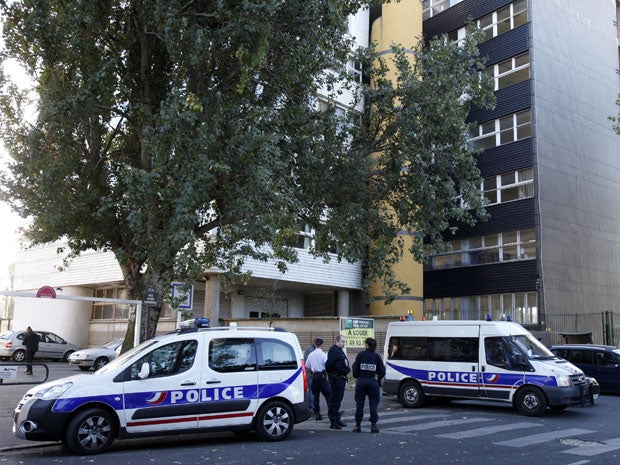 French police cars guard the satirical weekly Charlie Hebdo offices in Paris