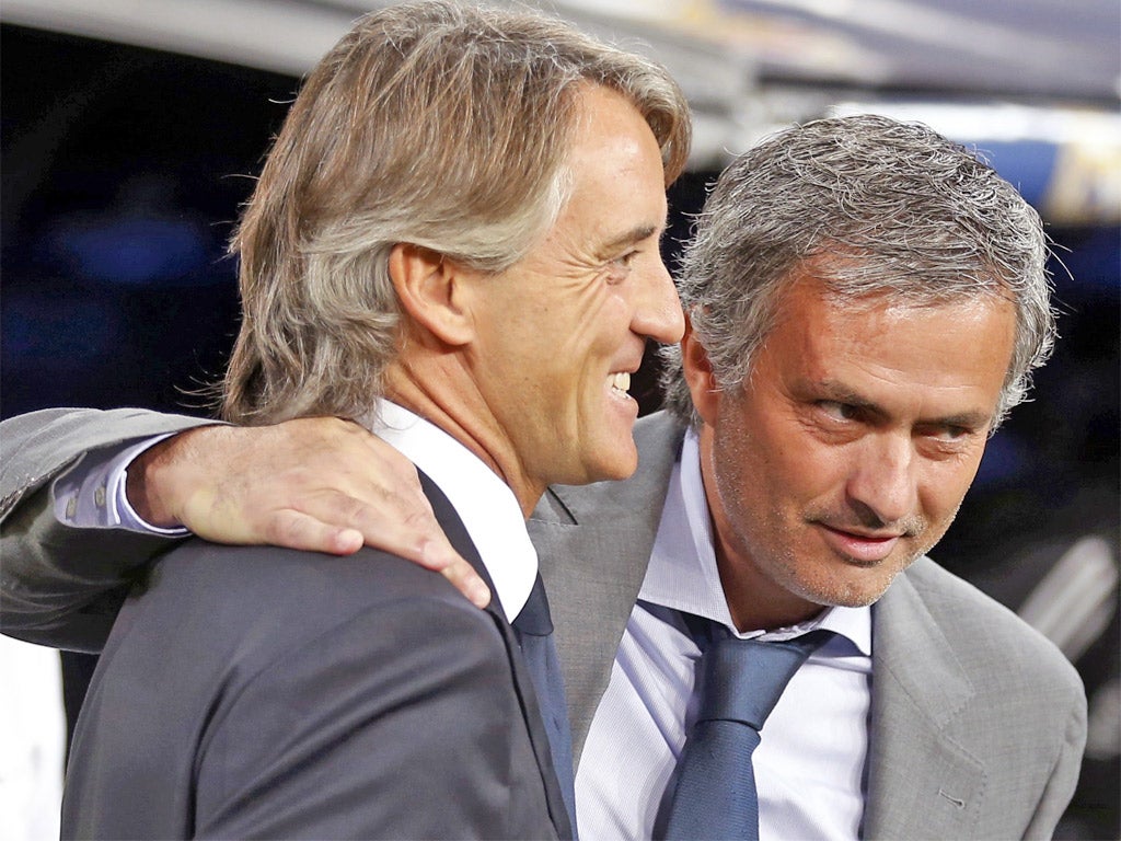 Jose Mourinho (right) got the better of Roberto Mancini at the Bernabeu on Tuesday