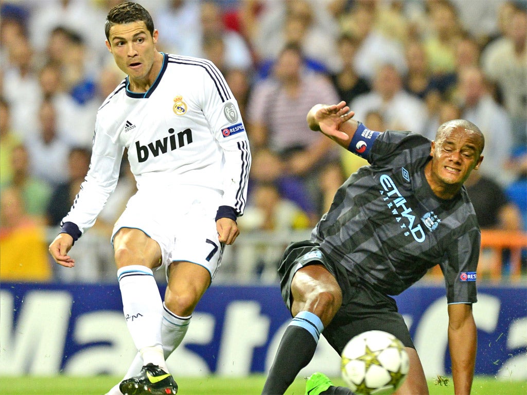 Real Madrid’s Cristiano Ronaldo vies with City’s captain Vincent Kompany