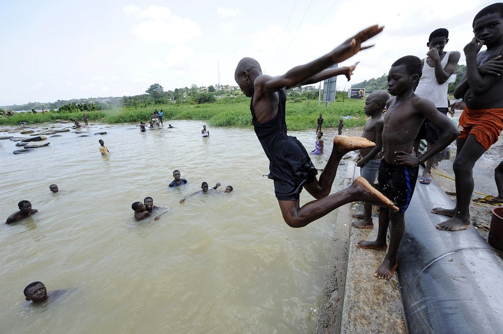 Boys dive and swim in the Ebrie laguna in a district of Abidjan on April 15, 2011.