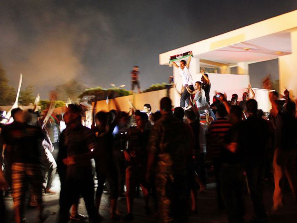Demonstrators cheer after storming the headquarters of the Islamist Ansar al-Sharia militia group in Benghazi.