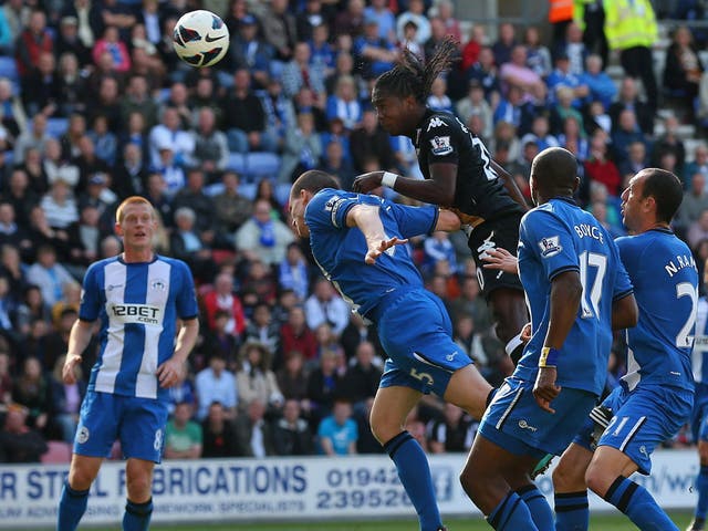 Fulham's Hugo Rodallega rises above the Wigan defence to power home a goal for his side