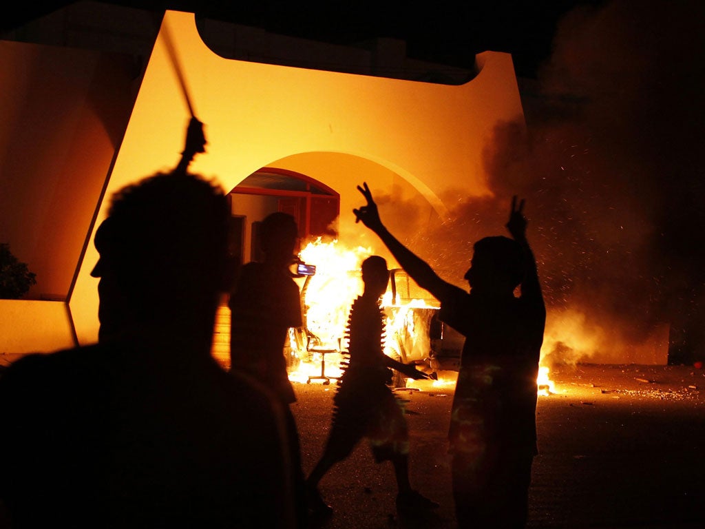 Celebrations as an Ansar al-Sharia car, said to contain ammunition, burns in Benghazi