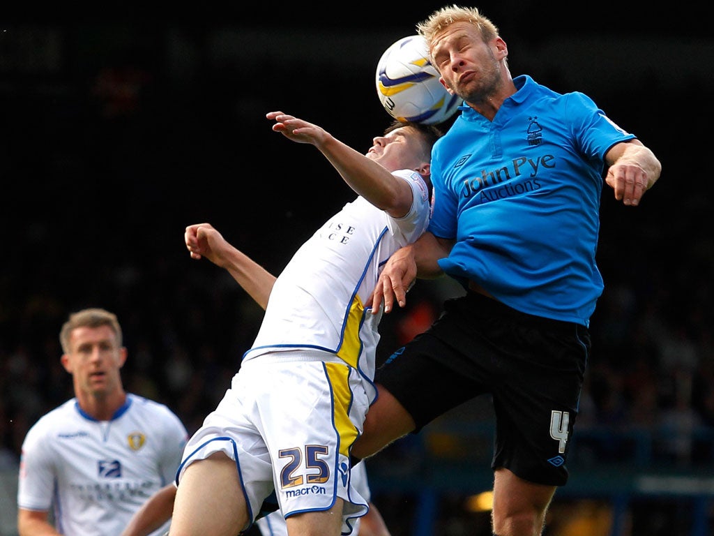 Lift off: Simon Gillett (right) rises above Leeds midfielder Sam Byram