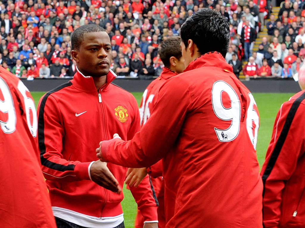 Patrice Evra and Luis Suarez shake hands at Anfield