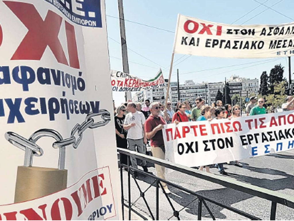 Journalists march in central Athens yesterday past a banner calling for a general strike on 26 September