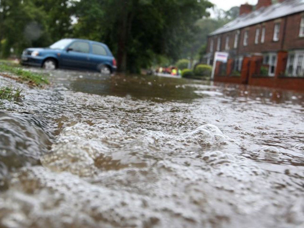 Flood waters pours into a residential street after the River Wansbeck broke its banks in Morpeth