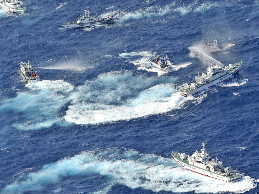 Japanese coast guard vessels spray water against Taiwanese fishing boats