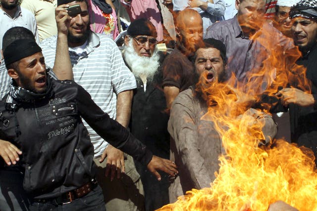 Jordanian protesters burn a US flag during a protest against an amateur film mocking Islam near the US embassy in Amman.