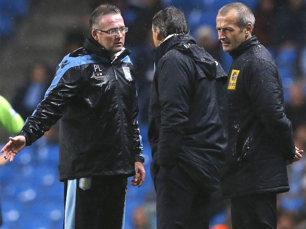 Mancini (centre) has words with the Aston Villa manager, Paul Lambert, after a poor tackle on Gareth Barry