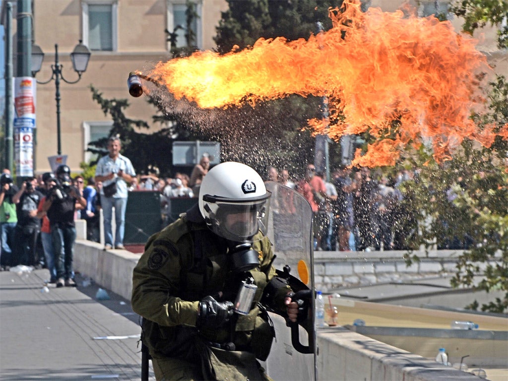 Firebombs explode in front of riot police during clashes yesterday