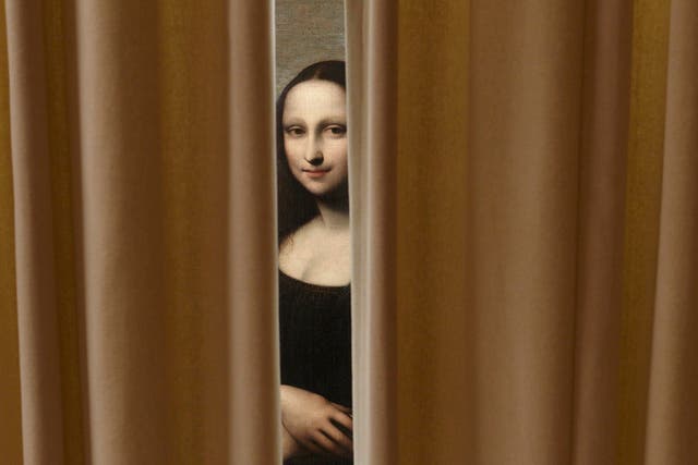 Another Mona Lisa? A painting attributed to Leonardo da Vinci and representing Mona Lisa is pictured behind a curtain during a preview presentation in a vault in Geneva September 26, 2012.