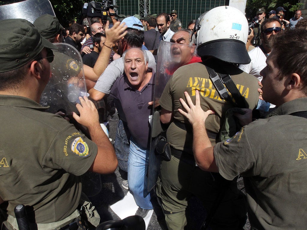 Demonstrators try to break police lines in Athens yesterday