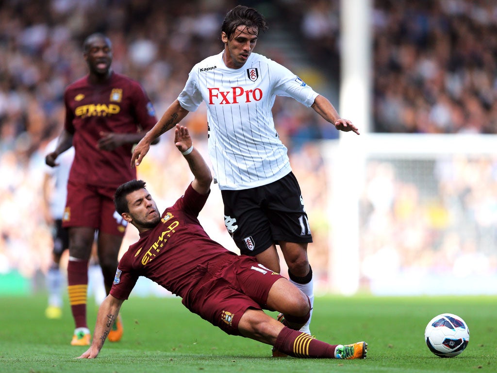 Bryan Ruiz of Fulham is tackled by Sergio Aguero of Manchester City