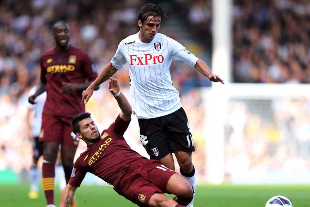 Bryan Ruiz of Fulham is tackled by Sergio Aguero of Manchester City